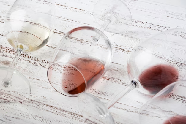 Wine-filled wine glasses resting on a wooden table