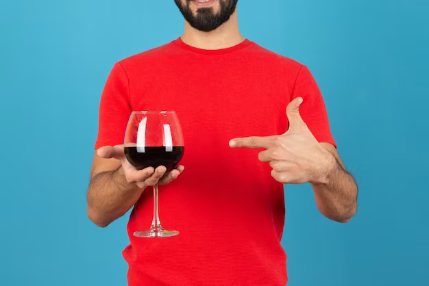 Young man pointing at a glass of red wine