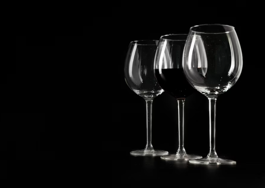 three empty glasses placed in a row on a black background